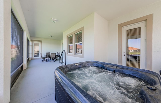 view of patio with visible vents and a hot tub