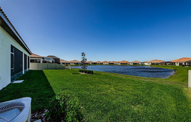 view of yard featuring a water view, fence, a residential view, and central air condition unit