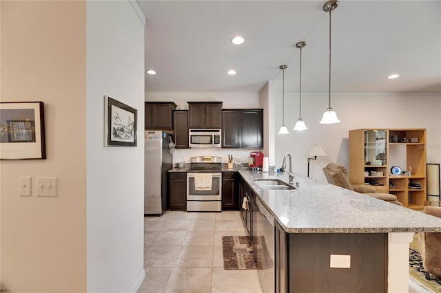 kitchen with dark brown cabinets, pendant lighting, a peninsula, stainless steel appliances, and a sink