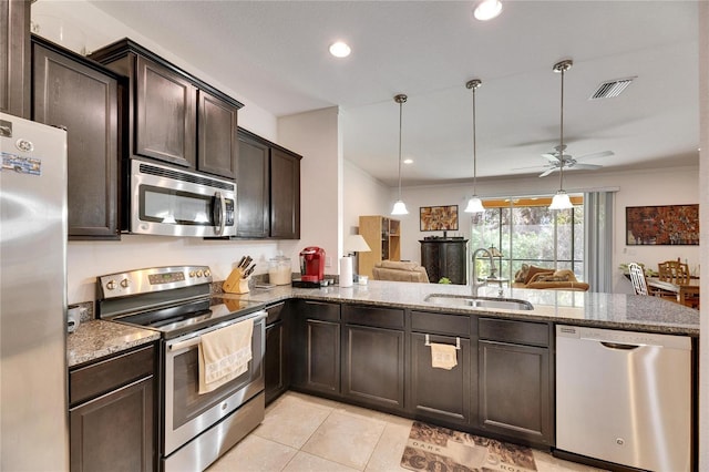 kitchen featuring visible vents, stone countertops, a sink, dark brown cabinetry, and appliances with stainless steel finishes