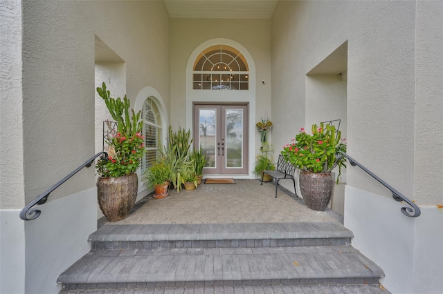 view of exterior entry with stucco siding and french doors