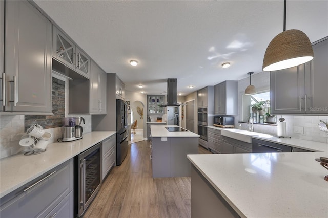 kitchen with wine cooler, gray cabinets, island exhaust hood, and wood finished floors