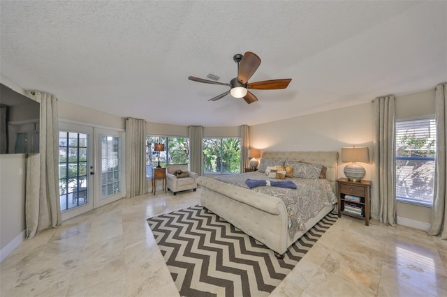 bedroom with access to exterior, french doors, multiple windows, and a textured ceiling