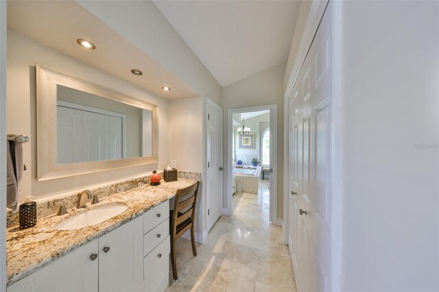 full bath featuring lofted ceiling, a garden tub, recessed lighting, and vanity