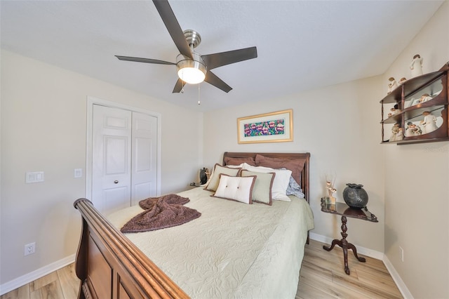 bedroom featuring a ceiling fan, light wood-type flooring, a closet, and baseboards