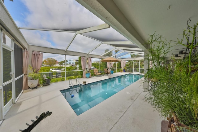 outdoor pool featuring a patio and glass enclosure