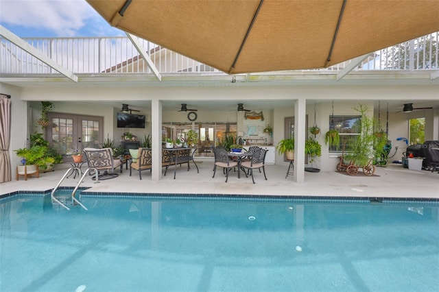 pool with french doors, a patio, a lanai, and ceiling fan