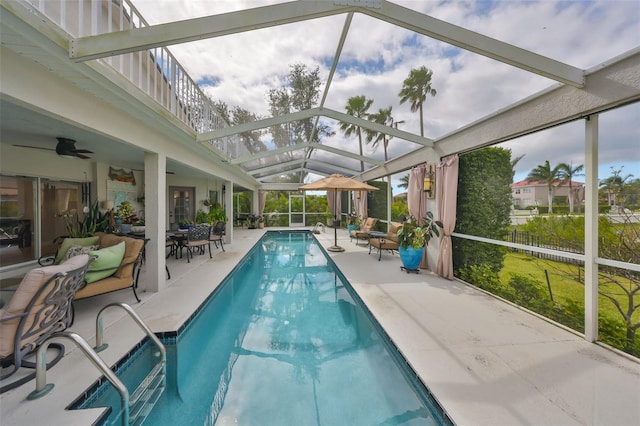 outdoor pool featuring ceiling fan, glass enclosure, and a patio area