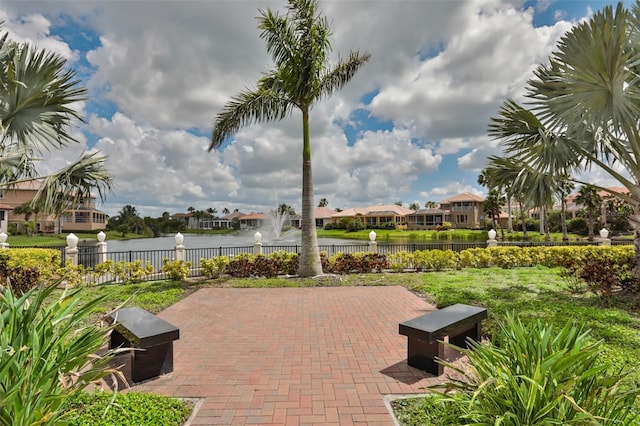 view of patio with a water view, fence, and a residential view