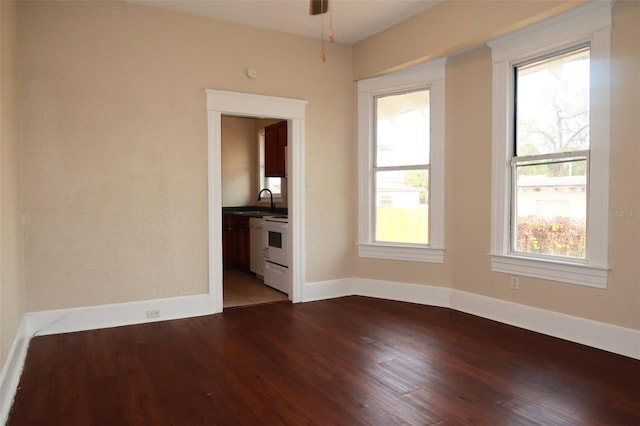 unfurnished room featuring a sink, baseboards, and wood finished floors