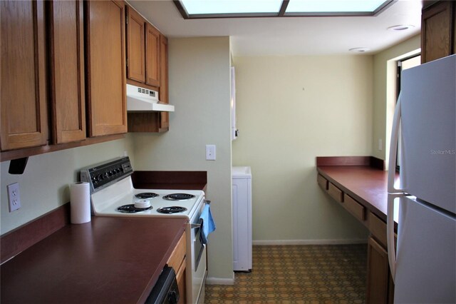 4983 Puritan Cir Unit 524, Tampa, FL 33617 - kitchen featuring white appliances, baseboards, dark countertops, under cabinet range hood, and brown cabinetry