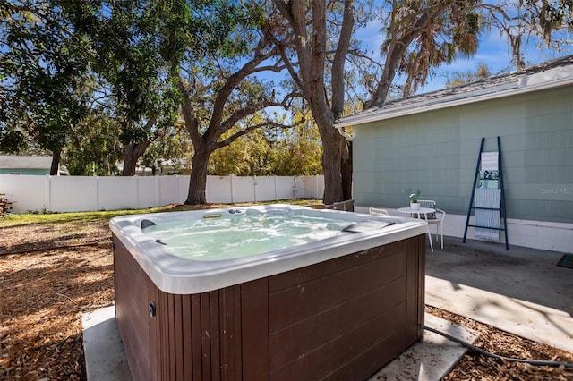 view of yard featuring a hot tub, a fenced backyard, and a patio