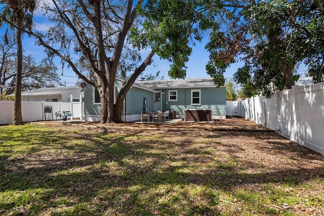 rear view of house featuring a patio area, a fenced backyard, and a yard