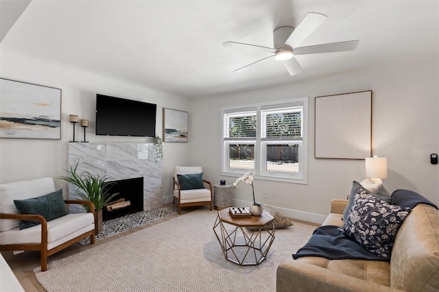 living area featuring ceiling fan, baseboards, and a high end fireplace