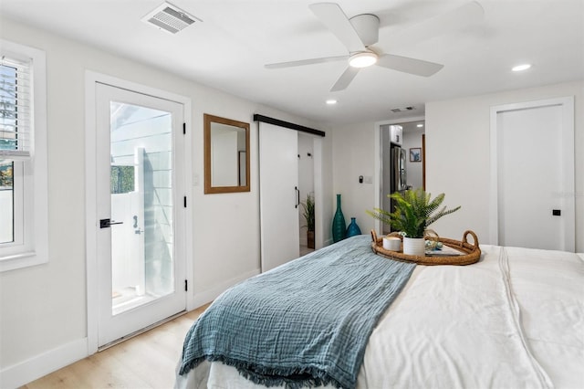 bedroom with multiple windows, visible vents, and light wood-style floors