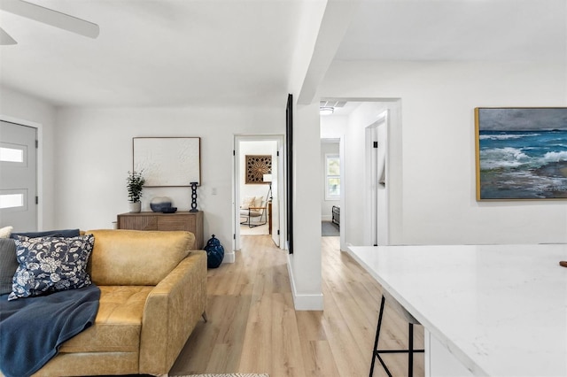 living area with light wood-style flooring and baseboards