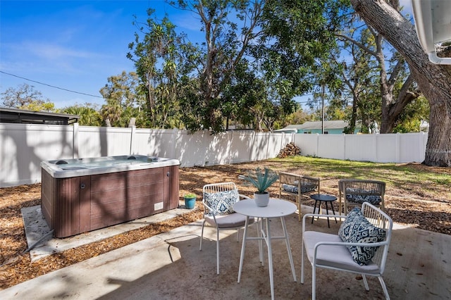 view of patio / terrace with a hot tub and a fenced backyard