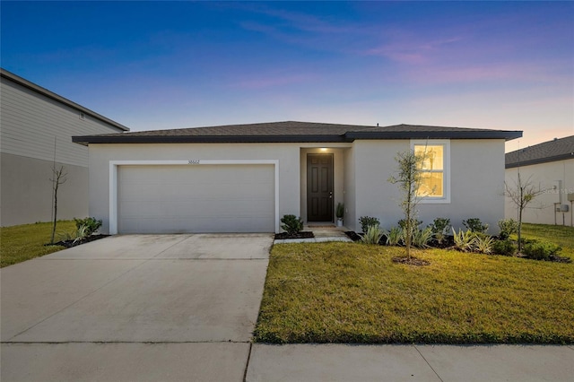 single story home with an attached garage, a front lawn, concrete driveway, and stucco siding