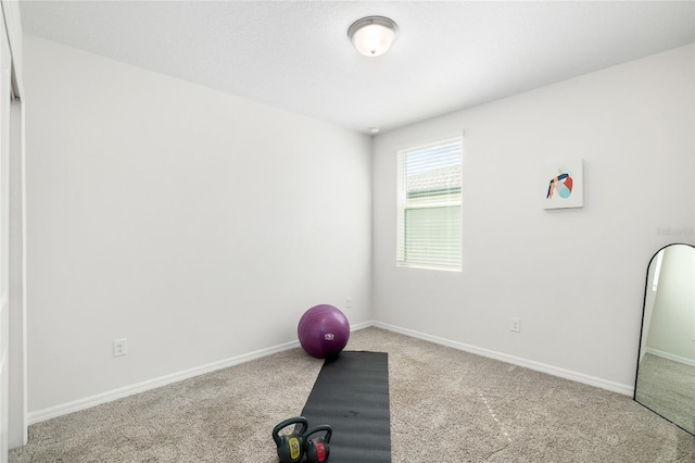 exercise area featuring carpet floors and baseboards