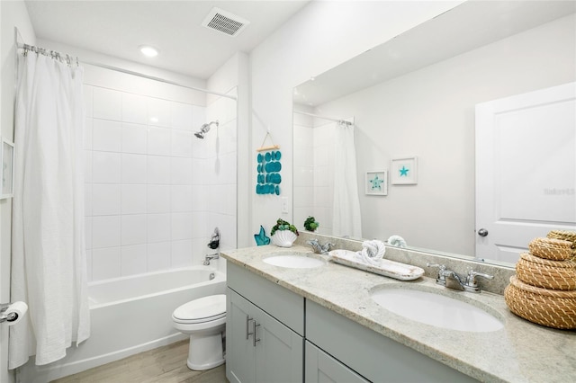 bathroom with toilet, visible vents, a sink, and wood finished floors