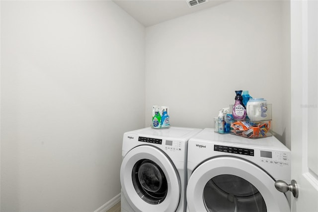 clothes washing area with laundry area, visible vents, independent washer and dryer, and baseboards