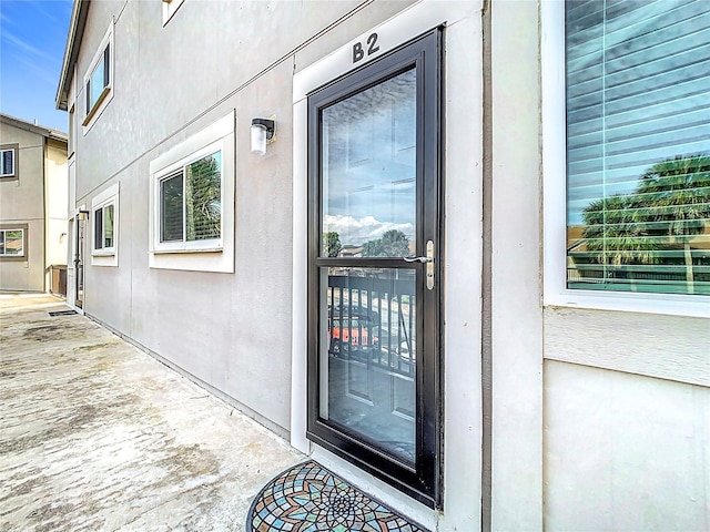 view of exterior entry featuring stucco siding