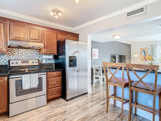 kitchen featuring crown molding, stainless steel appliances, tasteful backsplash, light wood-style flooring, and under cabinet range hood