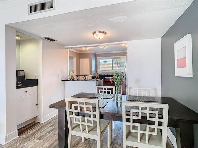 dining room with baseboards, visible vents, and wood finished floors