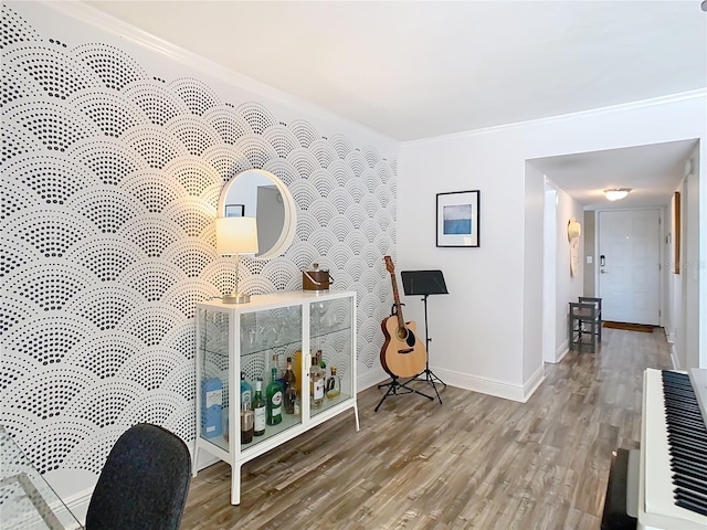 interior space with an accent wall, heating unit, baseboards, and wood finished floors