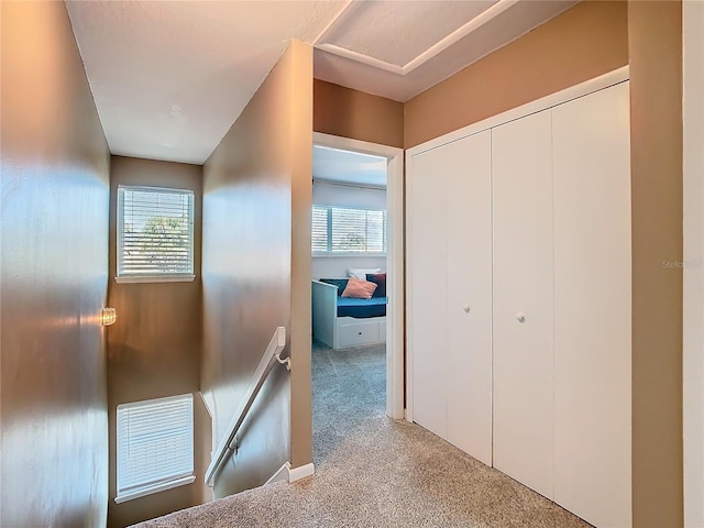 hall featuring carpet floors and an upstairs landing