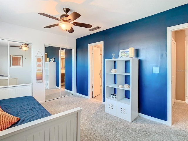 carpeted bedroom featuring a ceiling fan, connected bathroom, visible vents, and baseboards