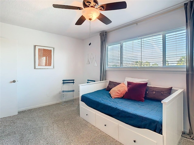 carpeted bedroom with ceiling fan and baseboards