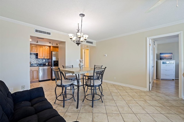 dining space with light tile patterned floors, ornamental molding, a textured ceiling, and visible vents