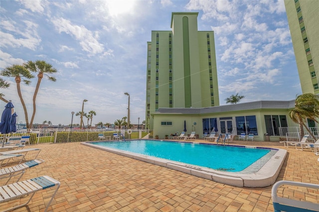 community pool with fence and a patio