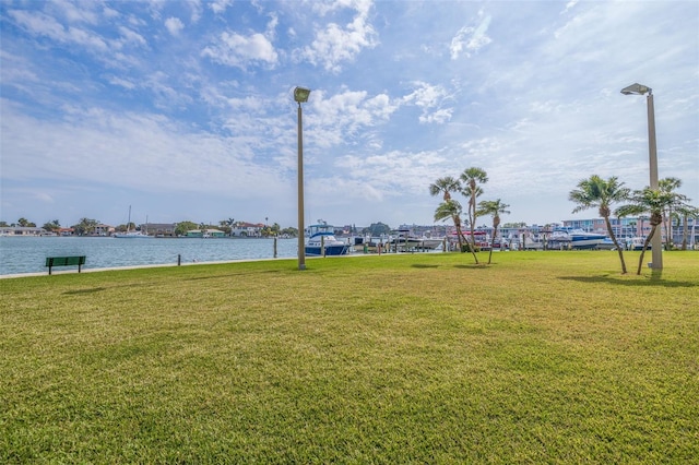 view of home's community with a lawn and a water view