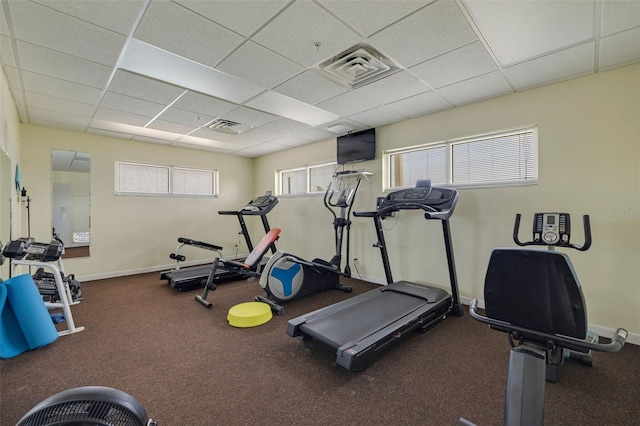 gym with a drop ceiling, visible vents, and baseboards