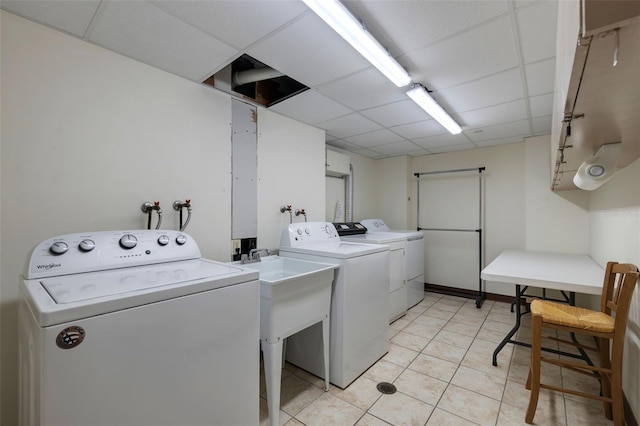 clothes washing area featuring laundry area, light tile patterned floors, and washer and clothes dryer