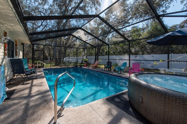 view of swimming pool with a patio, glass enclosure, a fenced backyard, and a fenced in pool