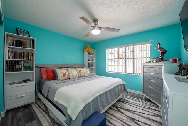 bedroom with ceiling fan, a textured ceiling, and wood finished floors