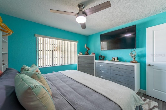 bedroom with a textured ceiling, ceiling fan, and wood finished floors