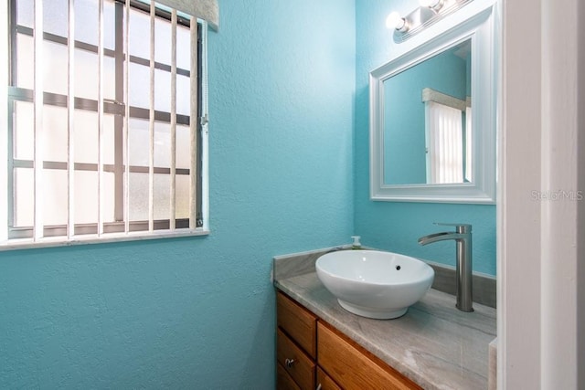 bathroom featuring a textured wall and vanity