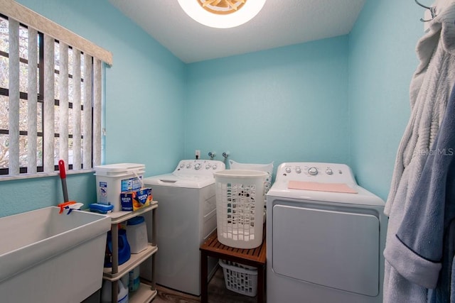 laundry room featuring laundry area, separate washer and dryer, and a sink