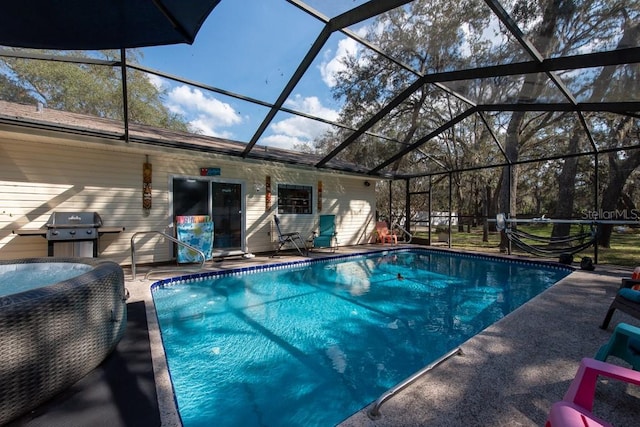 outdoor pool with glass enclosure, a patio, and area for grilling