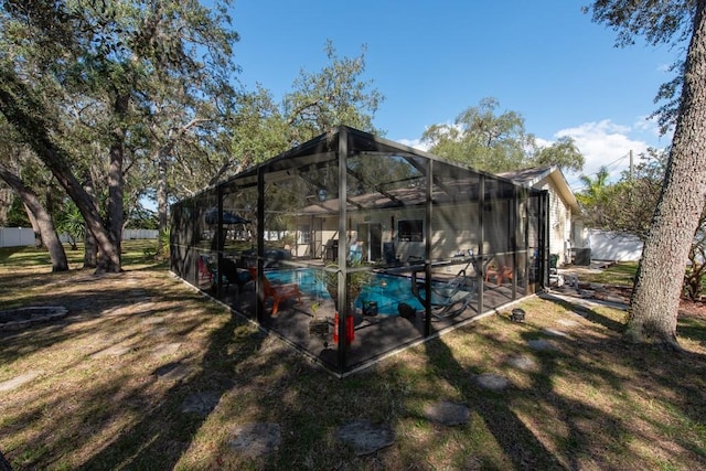 back of house featuring glass enclosure, a patio area, fence, and an outdoor pool