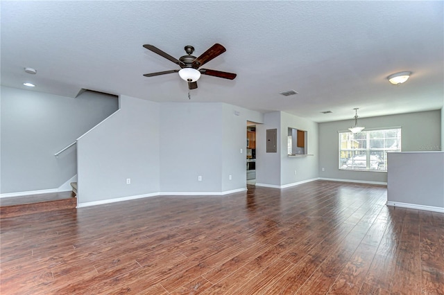 unfurnished living room with a ceiling fan, dark wood-style flooring, baseboards, and stairs