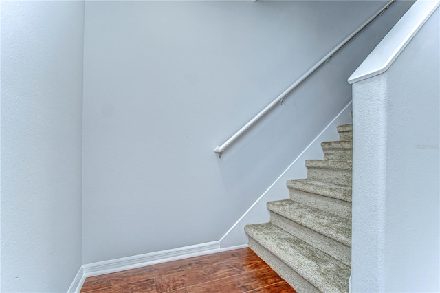 stairway featuring wood finished floors and baseboards