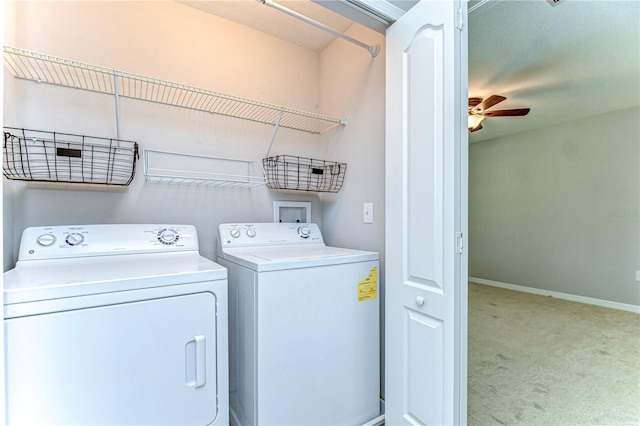 laundry area featuring washer and clothes dryer, light colored carpet, a ceiling fan, laundry area, and baseboards