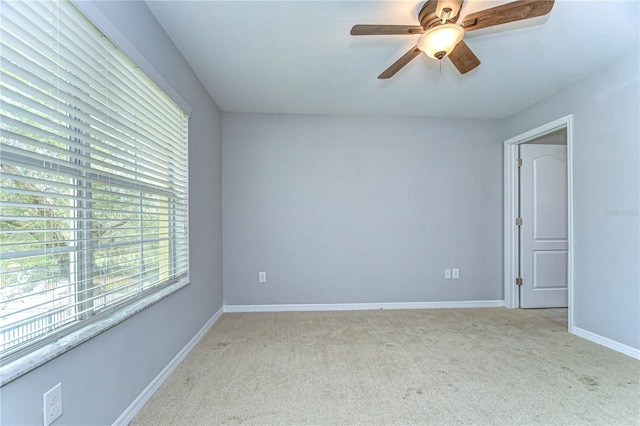 spare room with a ceiling fan, carpet flooring, and baseboards