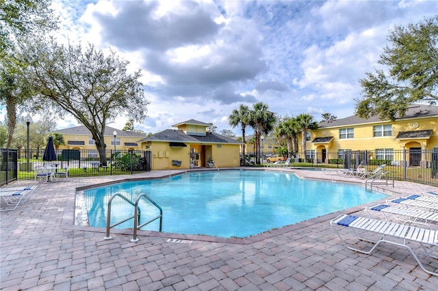 community pool featuring a patio area and fence