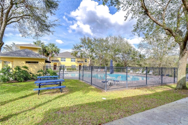 community pool with fence and a yard